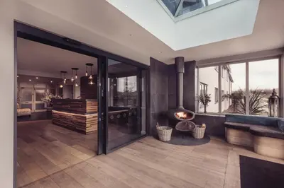 a living room with a fireplace and sliding glass doors at The Dunes Hotel in Barrow in Furness