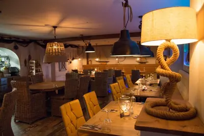 a restaurant with a table with a lamp on it at The Dunes Hotel in Barrow in Furness