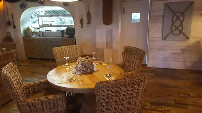 a wooden table with wicker chairs in a restaurant at The Dunes Hotel in Barrow in Furness