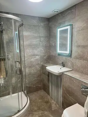a bathroom with a shower and a sink and a toilet at The Dunes Hotel in Barrow in Furness