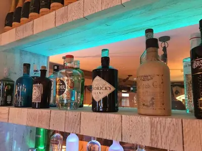 a bunch of bottles of alcohol sitting on a shelf at The Dunes Hotel in Barrow in Furness