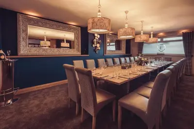 a long dining room with a long table and chairs at The Dunes Hotel in Barrow in Furness