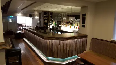 a bar in a restaurant with a large mirror at The Georgian Hollies Hotel in Blackpool