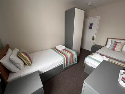 a small bedroom with two beds and a desk at The Georgian Hollies Hotel in Blackpool