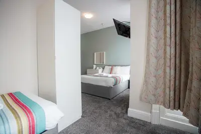 a bedroom with a bed and a television in it at The Georgian Hollies Hotel in Blackpool