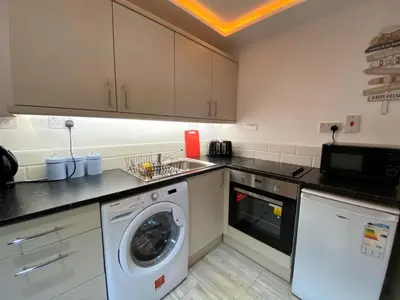 a kitchen with a washing machine and a washer at Kennedy House by Blackpool Service Apartments in Blackpool
