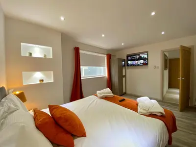 a bedroom with two beds with orange and white pillows at Kennedy House by Blackpool Service Apartments in Blackpool