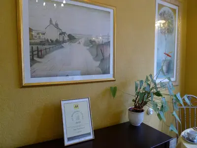 a picture hanging on a wall with a table with a picture at Bay Tree House Southport, United Kingdom in Southport