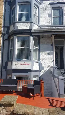 a house with two benches in front of it at The Sanderling in Morecambe