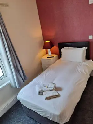 a bedroom with a bed with towels on it at The Sanderling in Morecambe