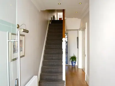 a staircase in a home with white walls and wooden floors at The Redstone Guesthouse in Blackpool
