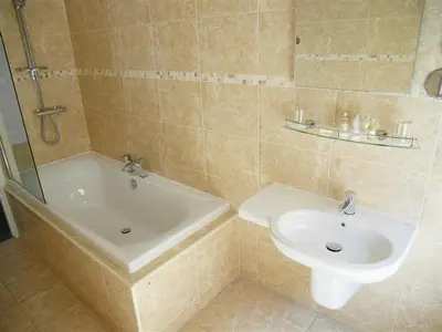 a bathroom with a sink and a tub and a toilet at The Redstone Guesthouse in Blackpool