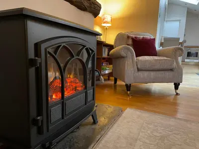 a fireplace in a living room with a couch and a chair at Stable Cottage Lytham in Lytham St Annes
