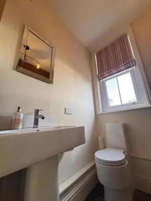 a bathroom with a sink and a toilet and a mirror at Stable Cottage Lytham in Lytham St Annes