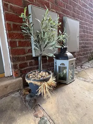 a potted plant and a lantern next to a brick wall at Stable Cottage Lytham in Lytham St Annes