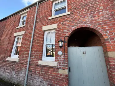 a brick building with a door and a window at Stable Cottage Lytham in Lytham St Annes