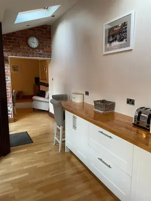 a kitchen with a counter and a living room at Stable Cottage Lytham in Lytham St Annes
