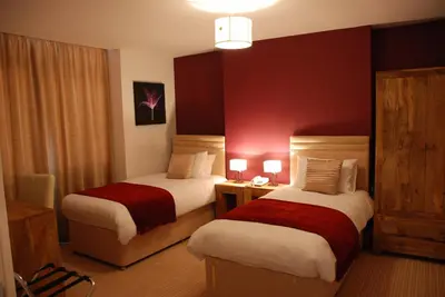 a hotel room with two beds with red walls at The Port House in Heysham