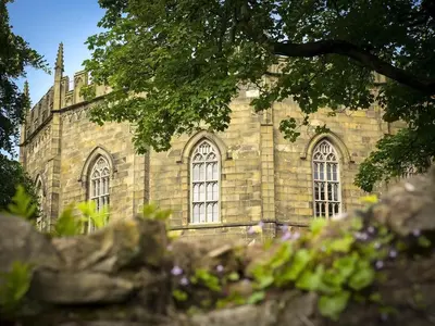 an old stone building with windows and a tree at Castle View in Lancaster