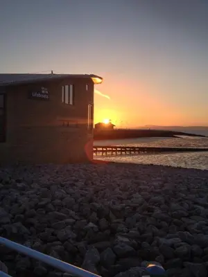a building on the beach with the sunset in the background at The Crown Hotel in Morecambe
