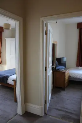 a room with two beds and a television and a bedroom at The Crown Hotel in Morecambe