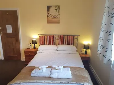 a bedroom with a bed with towels on it at The Gateway at Hest Bank in Lancaster