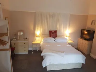 a bedroom with two beds and a television and two lamps at The Gateway at Hest Bank in Lancaster