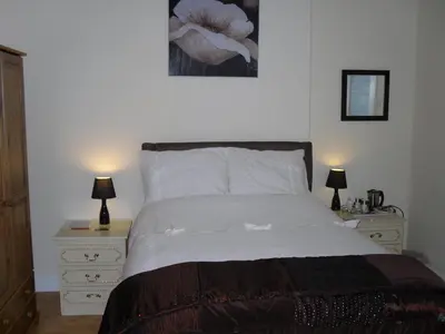 a bedroom with a bed with two night stands and two lamps at The Gateway at Hest Bank in Lancaster