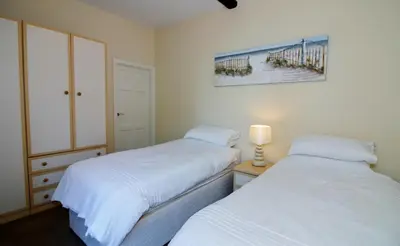 a bedroom with two beds and a picture of a pier at The Coach House Apartment in Lytham St Annes