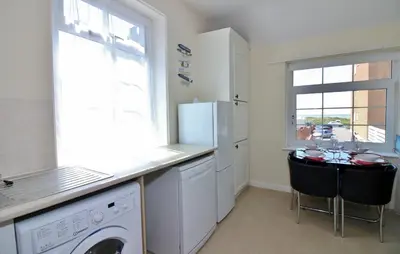 a kitchen with a washer and dryer next to a window at The Coach House Apartment in Lytham St Annes