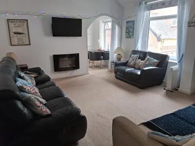 a living room with a couch and a fireplace at The Coach House Apartment in Lytham St Annes