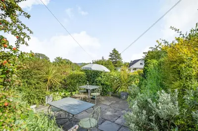 a patio with a table and chairs in a garden at 2 Beacon High in Lindale