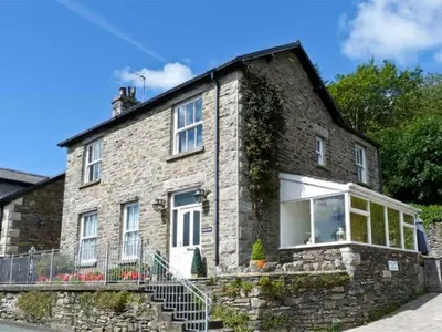 an old stone house with a stone staircase outside at Briarcliffe Cottage in Lindale