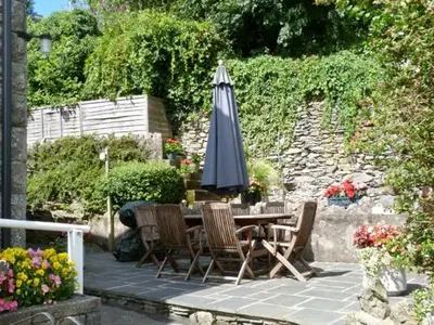 a table and chairs with an umbrella on a patio at Briarcliffe Cottage in Lindale