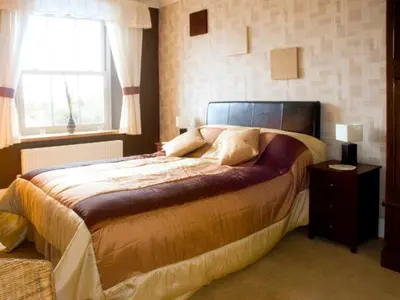 a bedroom with a large bed and a window at Briarcliffe Cottage in Lindale
