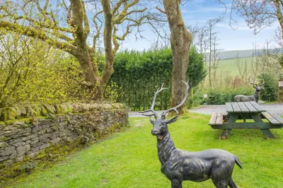 a statue of a deer standing in the grass at Hill Side Barn in Ireleth