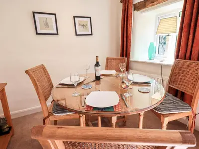 a dining room table with wine glasses on it at 4 Greencross Cottages in Holme