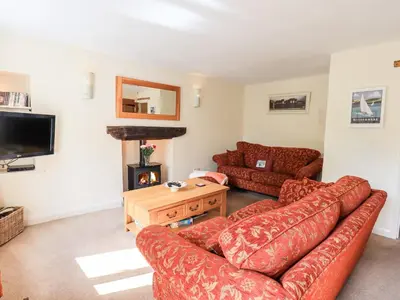 a living room with a couch and a fire place at 4 Greencross Cottages in Holme