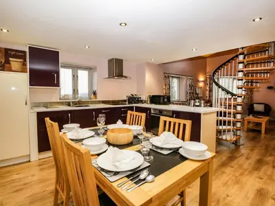 a kitchen and dining room with a table and chairs at Eller Riggs Cottage in Ulverston
