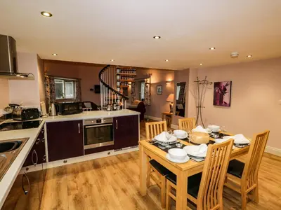 a kitchen and dining room with a table and chairs at Eller Riggs Cottage in Ulverston