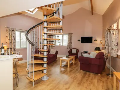 a spiral staircase in the living room of a house at Eller Riggs Cottage in Ulverston