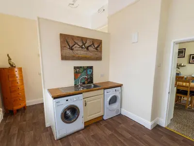 a laundry room with a sink and a washing machine at Roa Island House in Rampside