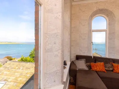 a living room with a couch and a view of the ocean at Roa Island House in Rampside