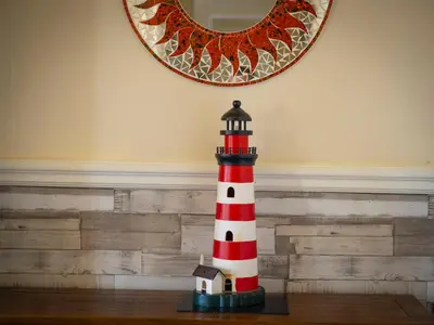a red and white lighthouse sitting on a table at Roa Island House in Rampside