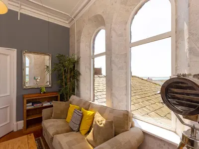 a living room with a couch and a large window at Roa Island House in Rampside