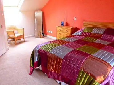 a bedroom with a bed and a dresser and a chair at The Crook in Great Urswick