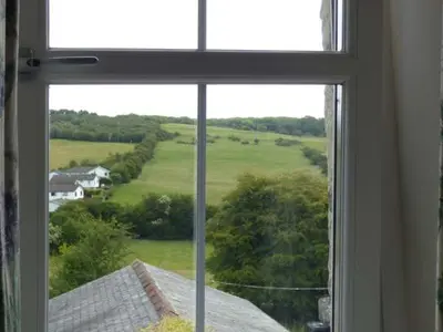 a window with a view of a field from a house at 2 West View in Holker