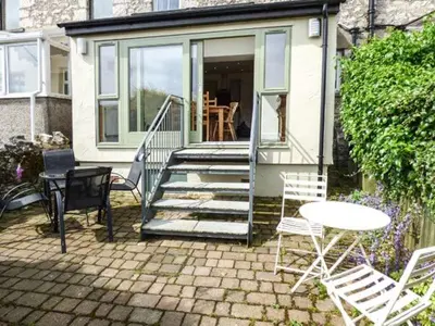 a patio with chairs and a table and a house at 2 West View in Holker