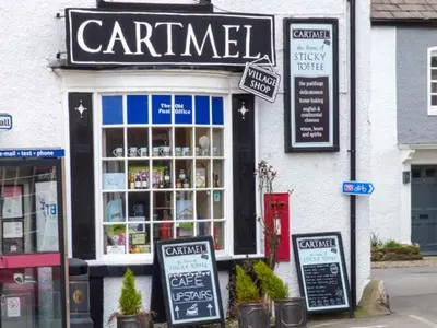a coffee shop with signs in front of it at 2 West View in Holker
