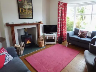 a living room with a couch and a fireplace at 2 West View in Holker